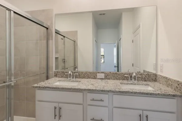 a bathroom with a granite countertop sink a mirror and a