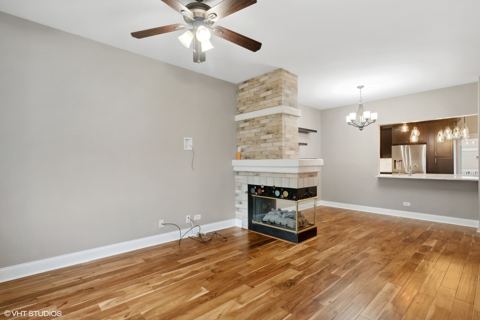 3443 Ravinia Circle Aurora, IL 60504 - Photo 9 of 36 an empty room with a fireplace and wooden floor