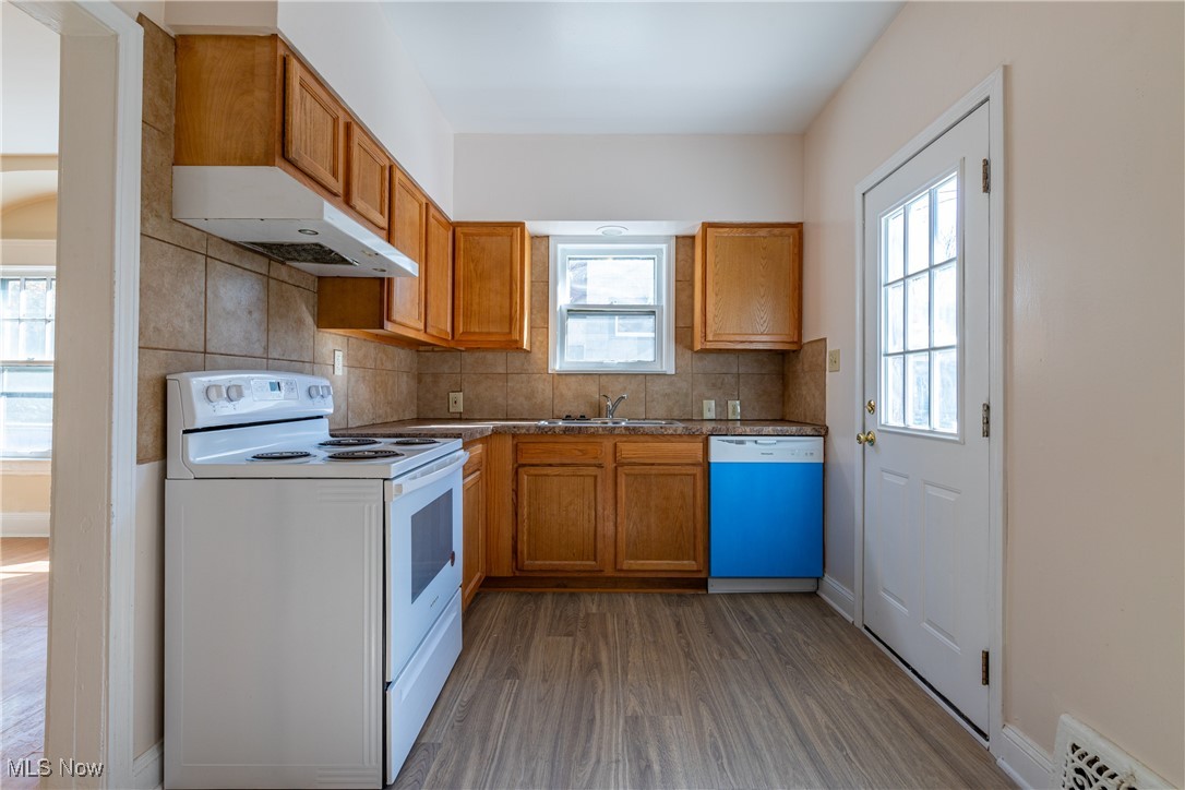 14426 Superior Road Cleveland, OH 44118 - Photo 17 of 50 Kitchen with dark hardwood / wood-style floors, sink, backsplash, and white appliances