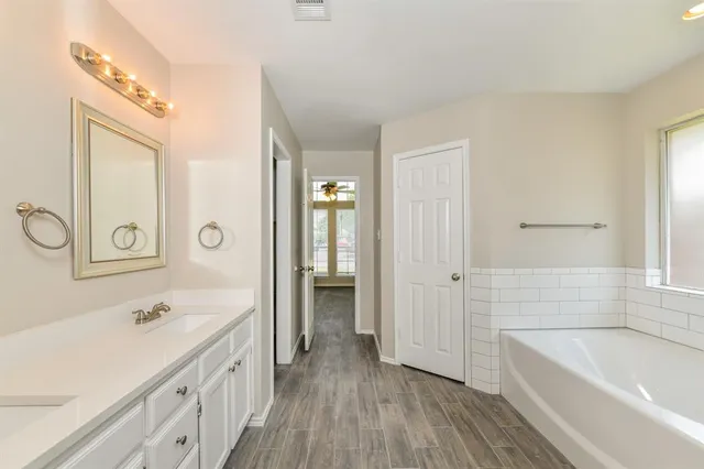 a bathroom with a sink a mirror and a bathtub