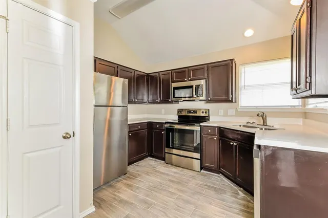 a kitchen with a refrigerator stove top oven and sink