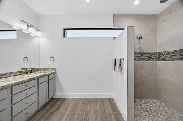 a bathroom with a sink a toilet a shower and a mirror