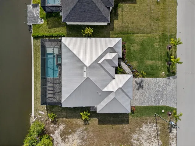 an aerial view of a house with a swimming pool outdoor seating and yard