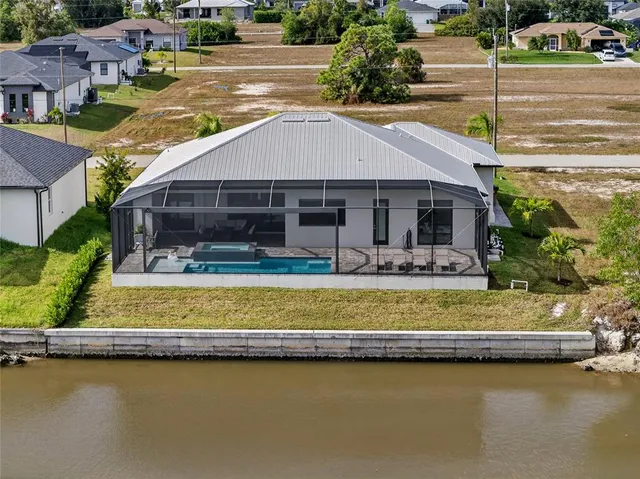 a front view of a house with a garden and lake view