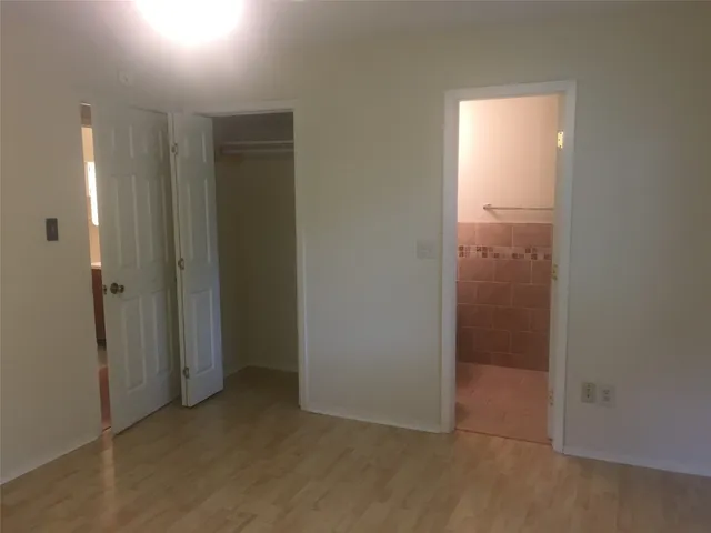 an empty room with closet and a bathroom