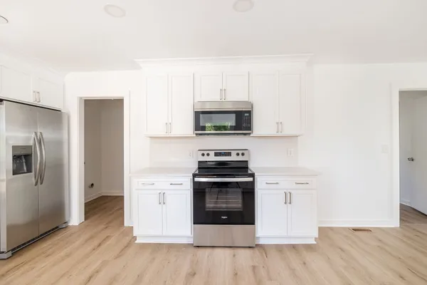 a kitchen with stainless steel appliances granite countertop a stove a sink and a refrigerator