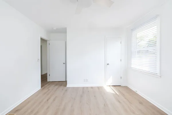 an empty room with wooden floor and windows