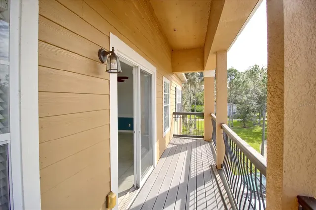 a view of a balcony with wooden floor and furniture