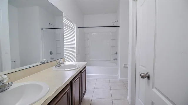 a bathroom with a granite countertop sink a mirror and a bathtub