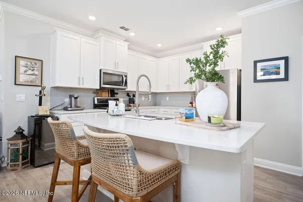 a kitchen with granite countertop a table chairs stove and cabinets
