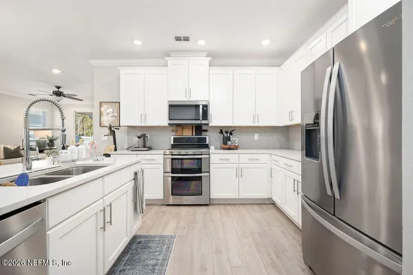 a kitchen with kitchen island white cabinets stainless steel appliances and sink