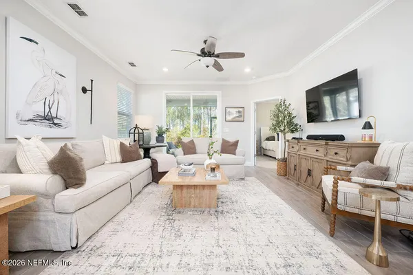 a living room with furniture flat screen tv and window