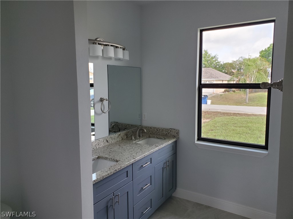 8072 Anhinga Road Fort Myers, FL 33967 - Photo 13 of 16 a bathroom with a granite countertop sink and a mirror