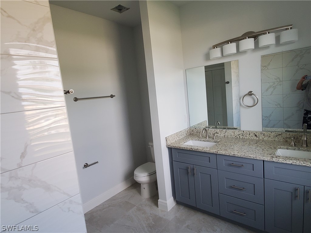8072 Anhinga Road Fort Myers, FL 33967 - Photo 16 of 16 a bathroom with a granite countertop sink toilet and mirror