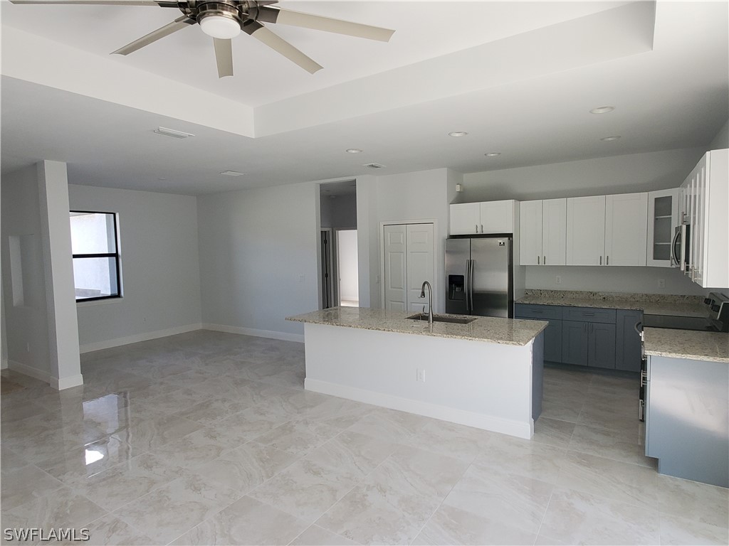 8072 Anhinga Road Fort Myers, FL 33967 - Photo 3 of 16 a living room with kitchen island furniture and a ceiling fan