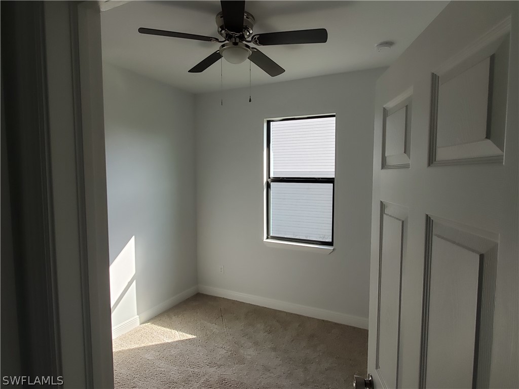 8072 Anhinga Road Fort Myers, FL 33967 - Photo 5 of 16 an empty room with windows and fan