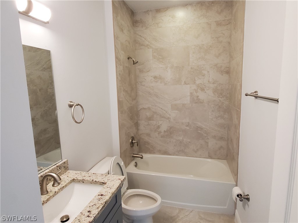 8072 Anhinga Road Fort Myers, FL 33967 - Photo 6 of 16 a bathroom with a granite countertop sink a toilet and bathtub