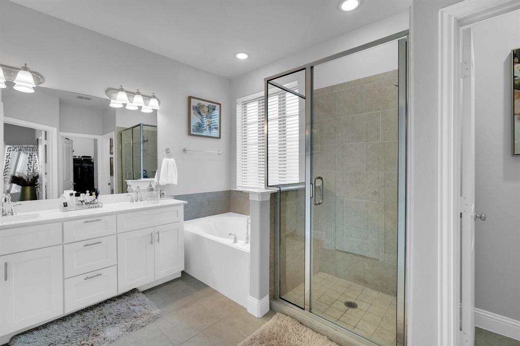 1498 Weston Road Dallas, TX 75234 - Photo 14 of 24 Glass-enclosed shower with tiled walls and floor, accompanied by a separate soaking tub