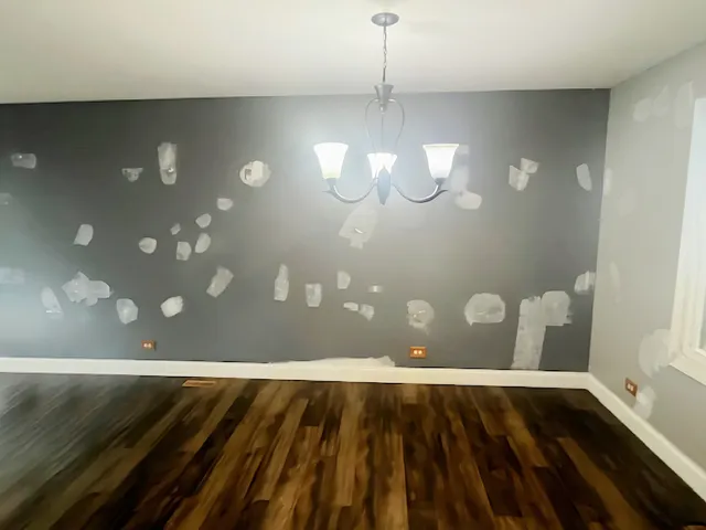a view of an empty room with wooden floor and chandelier