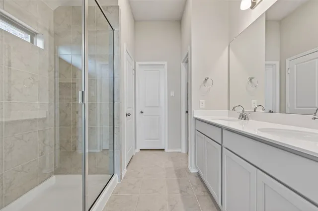 a spacious bathroom with a shower sink and mirror