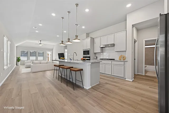 a kitchen with white cabinets and appliances