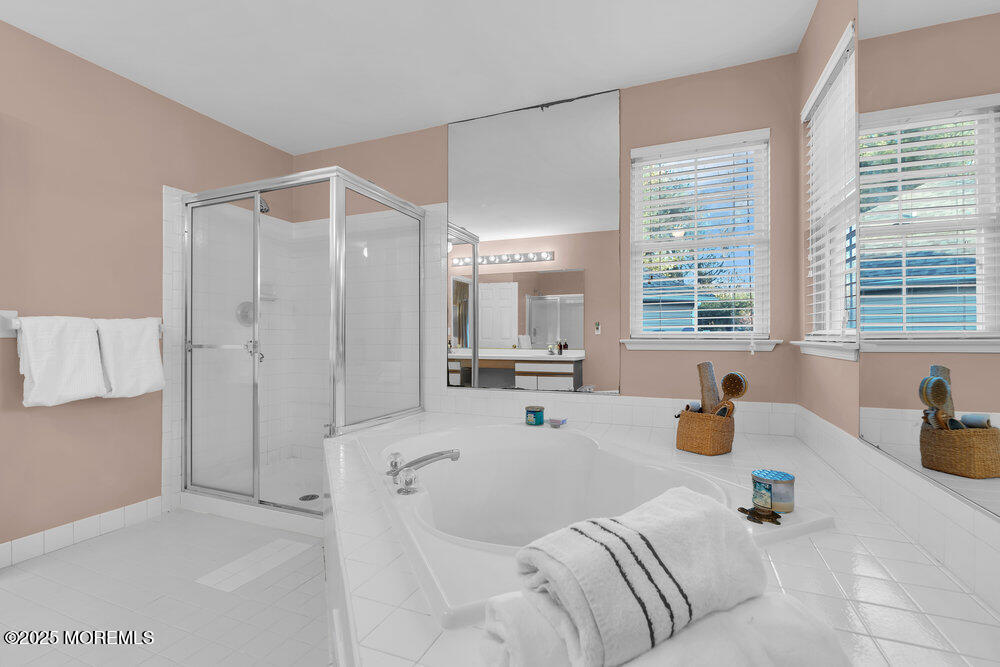 2 Blacksmith Pass Colts Neck, NJ 07722 - Photo 17 of 34 a spacious bedroom with a bed a couch and a window