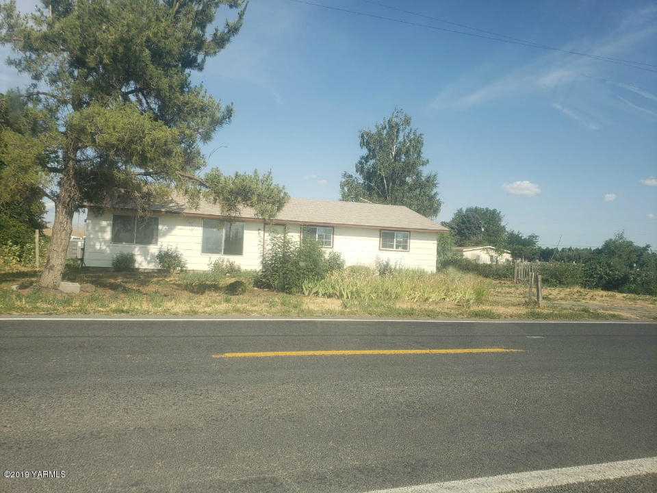 a view of a house and a yard next to a road