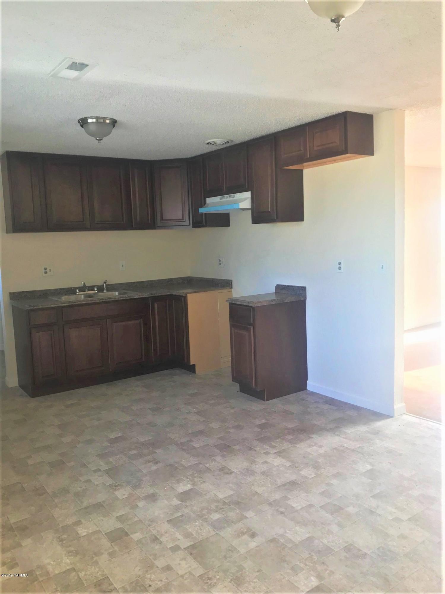 811 North County Line Road Grandview, WA 98930 - Photo 3 of 11 a kitchen with cabinets and wooden floor