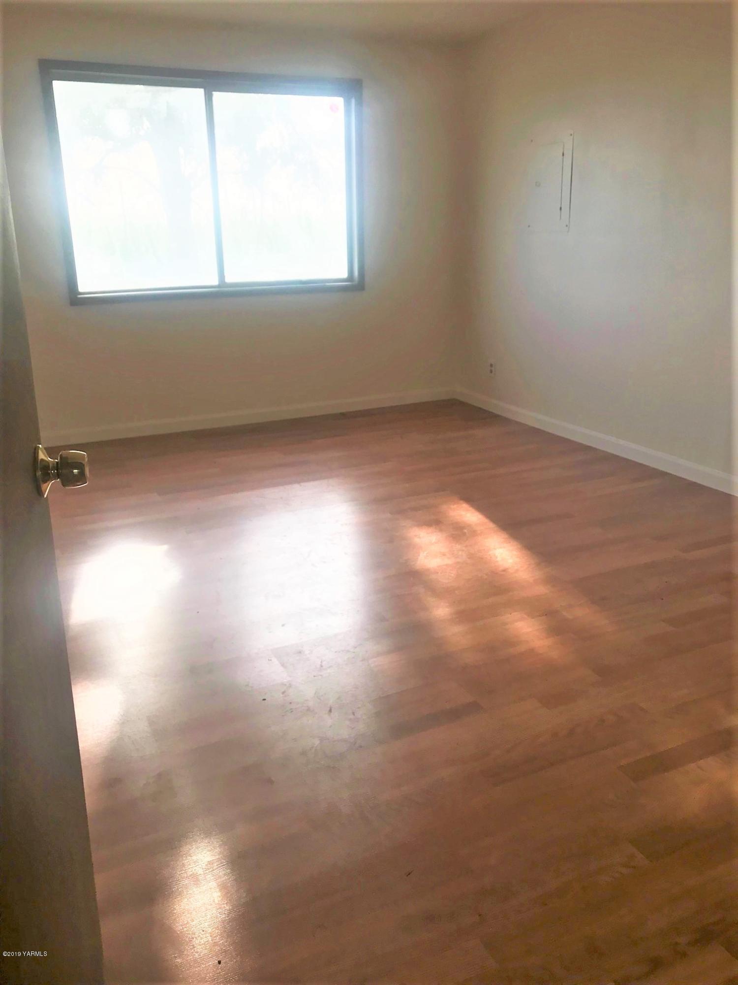 811 North County Line Road Grandview, WA 98930 - Photo 8 of 11 an empty room with wooden floor and windows