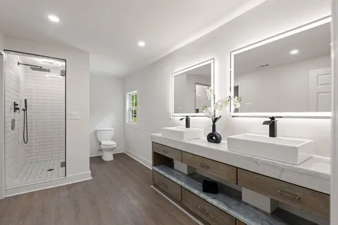 a bathroom with a double vanity sink a toilet and a mirror