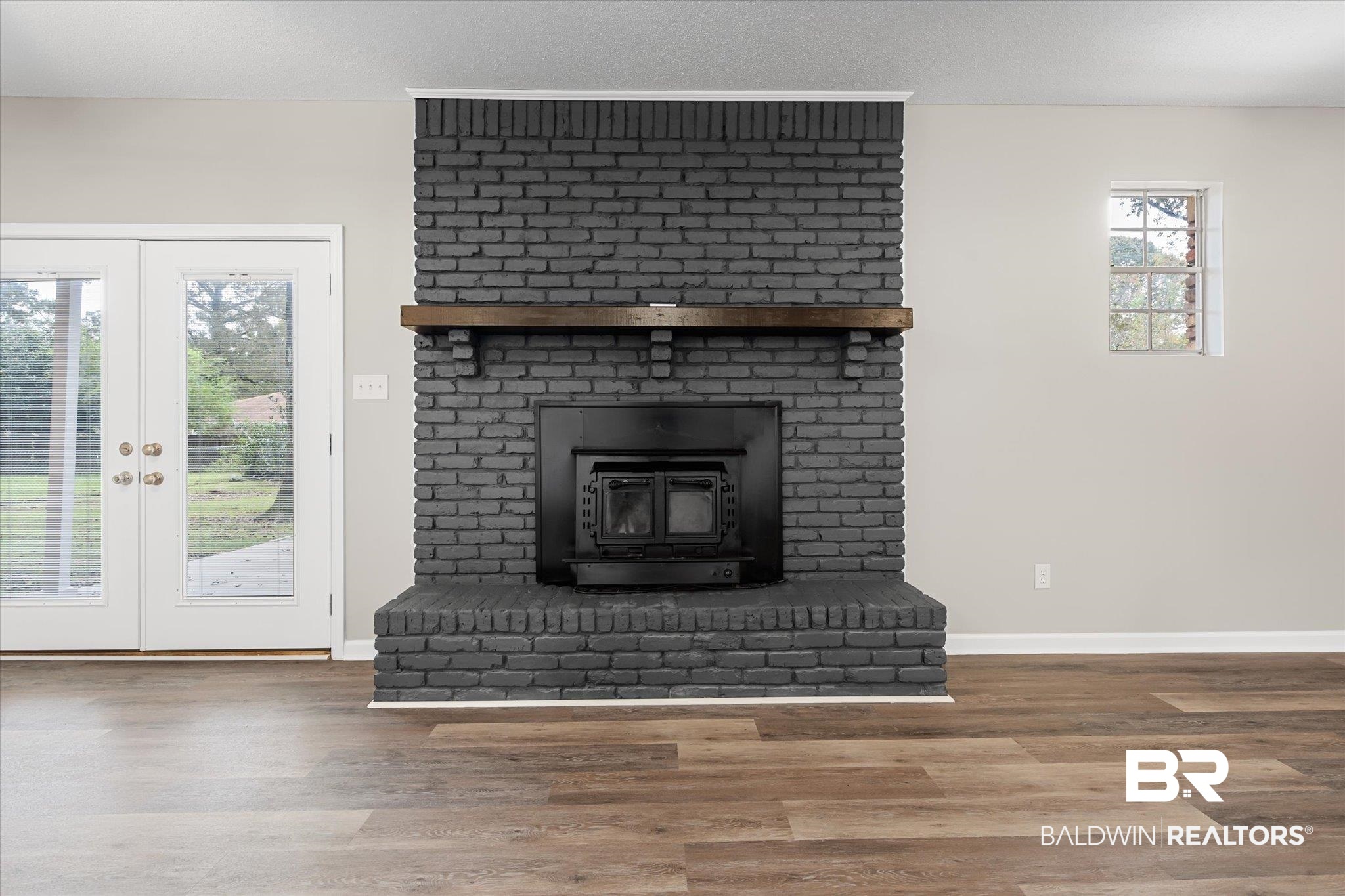 5015 Golfway Drive Eight Mile, AL 36613 - Photo 9 of 31 Unfurnished living room featuring a wood stove, french doors, and wood-type flooring