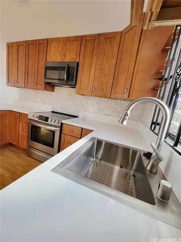 a kitchen with granite countertop a sink stove and microwave