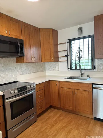 a kitchen with stainless steel appliances a stove a sink and a microwave