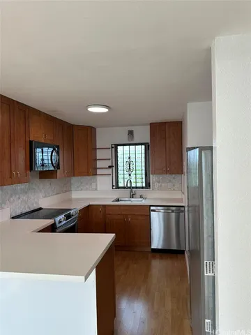 a kitchen with stainless steel appliances granite countertop a sink and a refrigerator