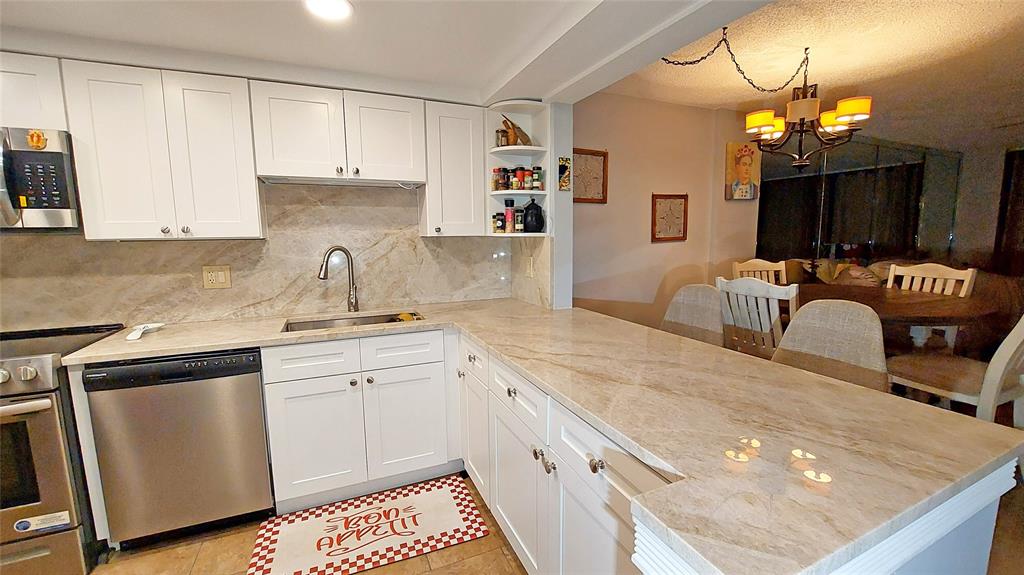 367 South Federal Highway, Unit C225 Deerfield Beach, FL 33441 - Photo 5 of 36 a kitchen with a sink dishwasher and white cabinets with wooden floor