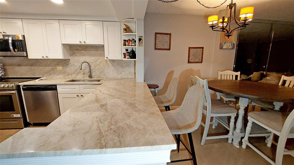 367 South Federal Highway, Unit C225 Deerfield Beach, FL 33441 - Photo 7 of 36 a kitchen with stainless steel appliances granite countertop a sink dishwasher and cabinets with wooden floor