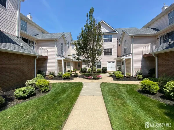 a front view of a house with a yard and potted plants