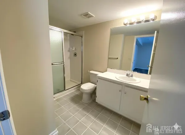 a bathroom with a double vanity sink toilet mirror and shower