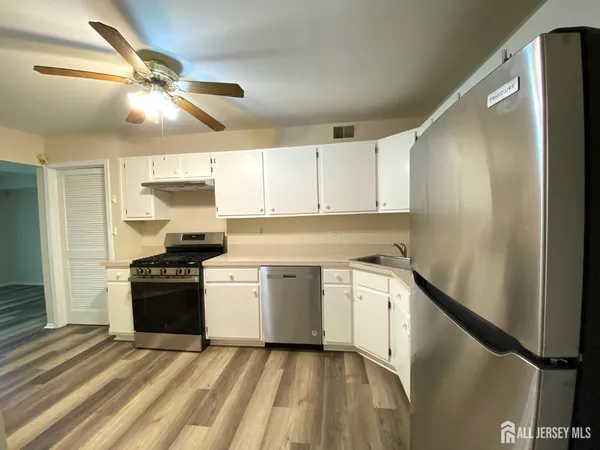 a kitchen with a stove refrigerator and cabinets
