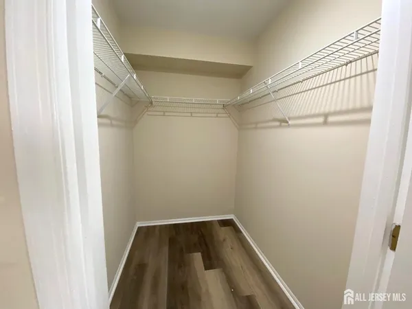 a view of walk in closet with wooden floor