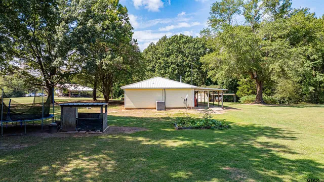 a backyard of a house with table and sofas