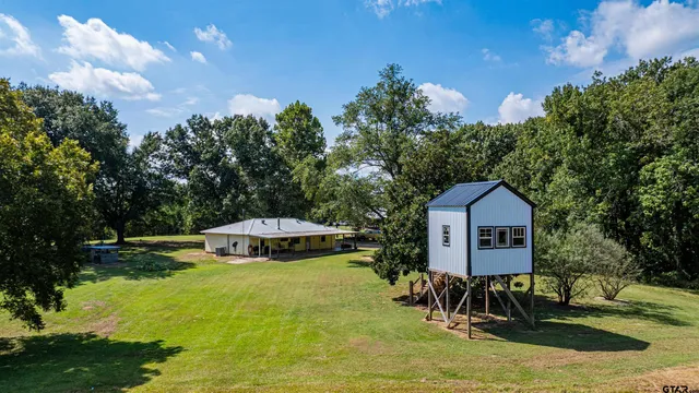 a view of a house with backyard and trees