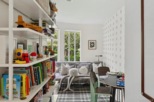 a living room with lots of baby furniture and a book shelf