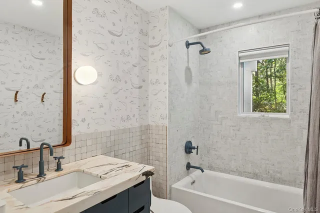 a bathroom with a granite countertop sink a toilet and shower