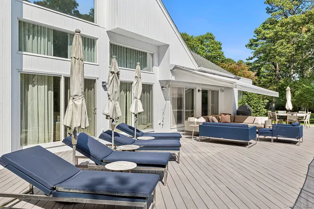 a view of a patio with couches table and chairs and potted plants