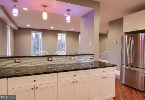 a kitchen with stainless steel appliances granite countertop a stove a sink and white cabinets