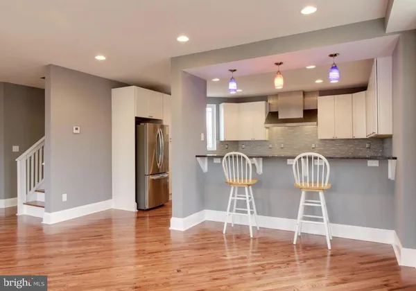 a kitchen with granite countertop a refrigerator and a sink