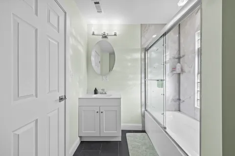 a bathroom with a double vanity sink a mirror and a bathtub