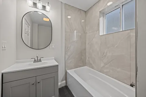 a bathroom with a sink a bathtub and a mirror