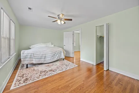 a bedroom with a bed and wooden floor